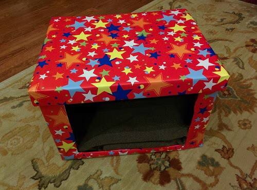 diy-cardboard-cat-bed DIY Cardboard cat bed covered in red fabric with different colored stars.