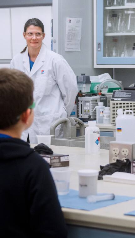 Membre de l’équipe de recherche du Centre mondial de nutrition animale montrant le laboratoire de recherche à un groupe d’enfants